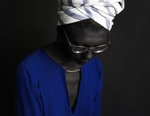 Photo portrait of a girl in a turban and sunglasses blouse painted dark gray paint skin