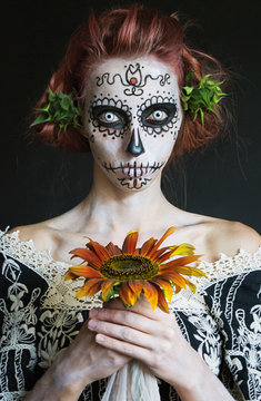 photo portrait of a girl in the image los Muertos with a sunflower in the hands
