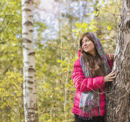 Женщина в платке в лесу стоит возле дерева