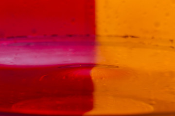 Drops, sprays, splashes of water on a colorful background