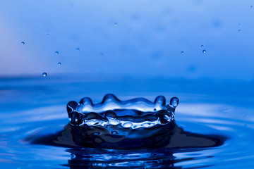 Drops, sprays, splashes of water on a colorful background