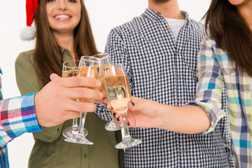 Young people in santa hats celebrating xmas with champagne