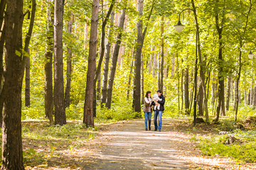 Obraz premium love, parenthood, family, season and people concept - smiling couple with baby in autumn park