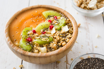 Smoothie with fruit,cereals and chia on white wooden table

