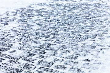 Sidewalk Cobblestone pavement covered with snow and ice