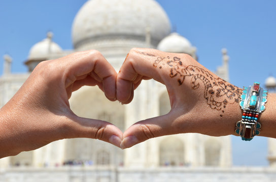 Heart-shaped hands against Taj Mahal. Agra, India