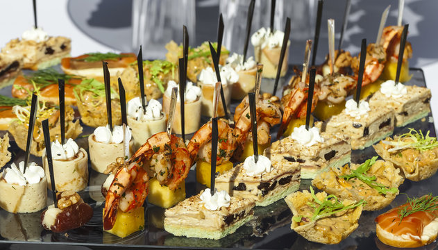 Catering service . sandwiches meat, fish, vegetable canapes on a festive wedding table outdoor