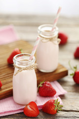 Strawberry yogurt in bottle on wooden table