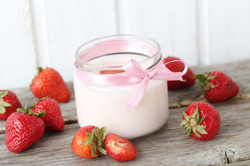 Strawberry yogurt in glass on wooden table