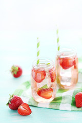 Fresh strawberry drink in bottle on wooden table
