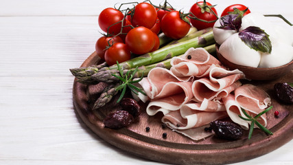 Fresh prosciutto with basil and mozzarella