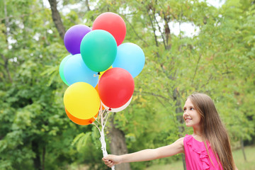 Portrait of  little girl with balloons in the park