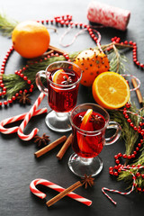 Mulled wine in glass on black wooden table