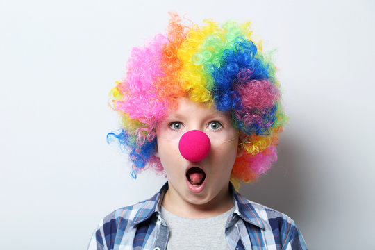 Portrait of  little boy clown on grey background