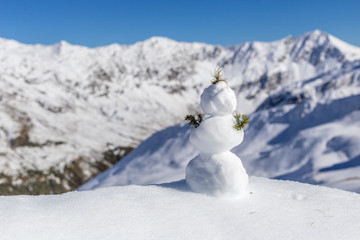 Fototapeta premium One little snowman on the top of mountains
