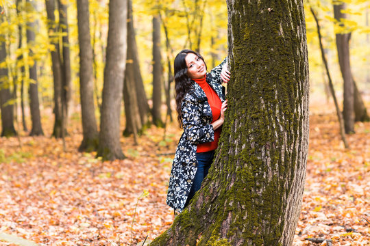 autumn park, beautiful smiling woman and falling yellow leaves