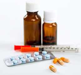 Various cold prescription bottles and a syringe isolated on a wh
