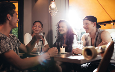 Group of friends sitting in cafe and having fun