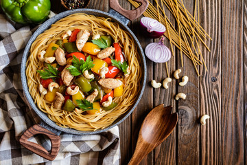 Whole meal spaghetti with chicken meat, pepper and cashew nuts