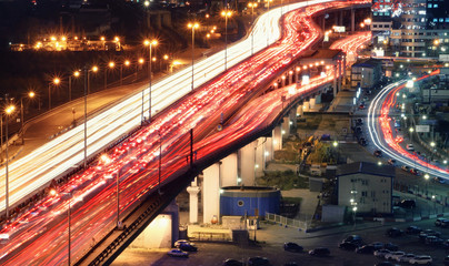 Fototapeta na wymiar Traffic jam on automobile overpass at night, view from above. . light trails of cars on a highway.