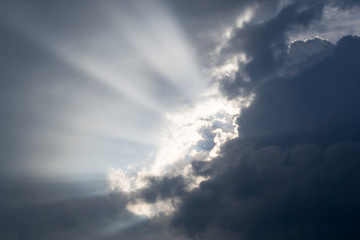 Bright sun rays shining through the storm clouds. Expressive