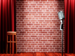 Vintage metal microphone against red curtain on empty theatre stage