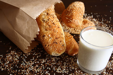 Bread rolls with seeds and glass of milk
