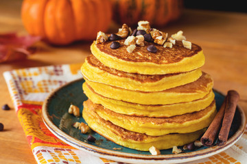 Pumpkin pancakes with nuts and chocolate on plate. Close up
