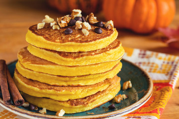 Pumpkin pancakes with nuts and chocolate on plate. Close up