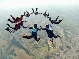 Rolgordijnen Skydiving friends holding hands © Mauricio G