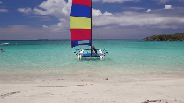 Young man launching a Catamaran at Cinnamon Bay, St John, United States Virgin Islands