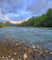 Bubbling streams of the mountain river at sunset.