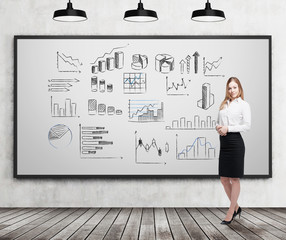Smiling blond businesswoman with various graphs