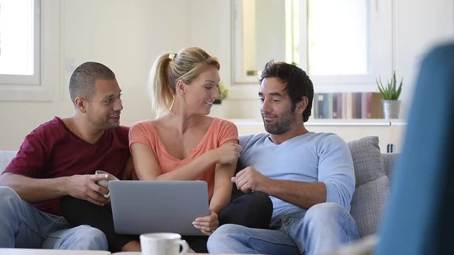 Group of friends sitting in couch websurfing on internet