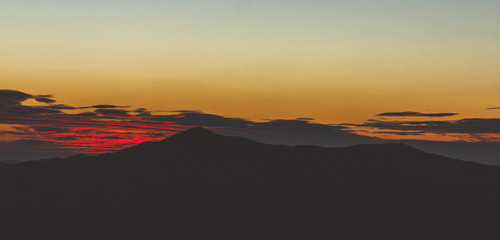 Fototapeta na wymiar Sunset behind mountain silhouette