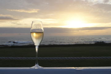 One glass of champagne during sunset on an outdoor terrace overlooking the ocean