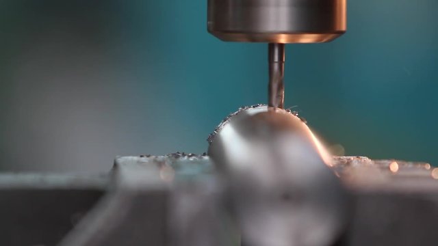 Frez obrabia metalową tulejkę powodując odpryskiwanie opiłk&oacute;w metalu