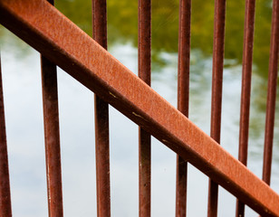 Rusted metal beam diagonal across smaller bars.