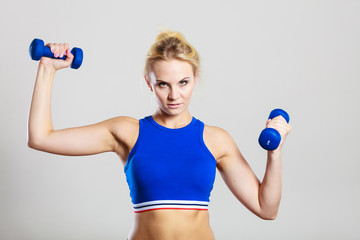 Fototapeta na wymiar Fit woman lifting dumbbells weights