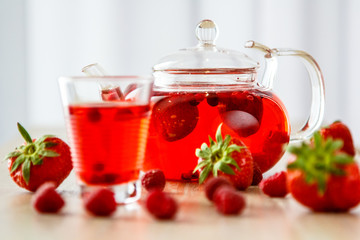 Tea in a glass teapot from the strawberries and raspberries