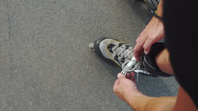 Man preparing for roller skating, putting on rollerskates 4K