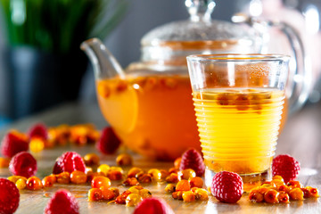 Tea in a glass teapot from sea buckthorn and raspberry.