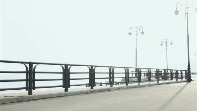 Young sporty man roller skating on summer waterfront 4K