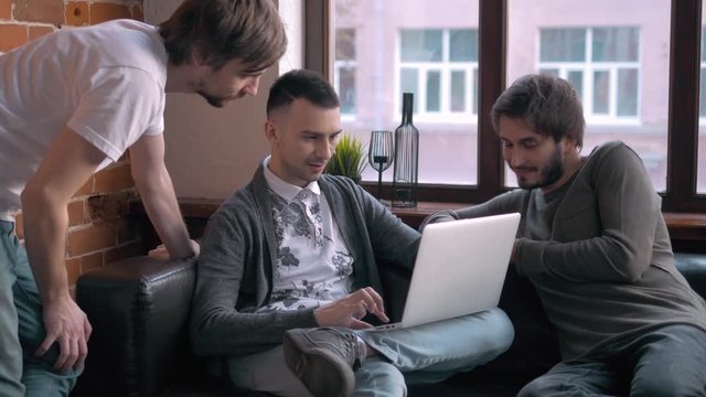 Group of entrepreneurs working and taking notes together in a little office. Freelancer meeting, man with laptop drink coffee in coworking.