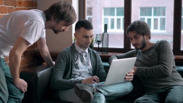 Group of entrepreneurs working and taking notes together in a little office. Freelancer meeting, man with laptop drink coffee in coworking.