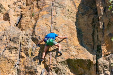 Obraz premium Male rock climber climbing up a cliff