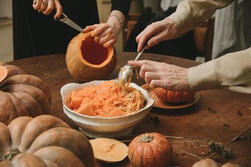 man and woman hands curving pumpkin