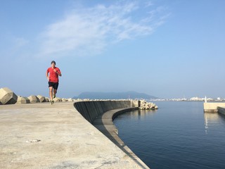 Man running along harbor sea wall