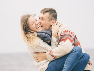 Young attractive couple in knitted sweaters having fun