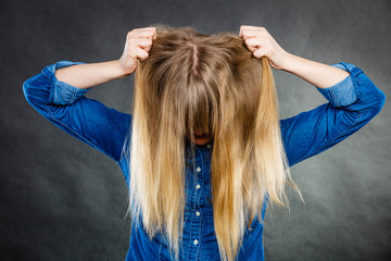 Furious woman pull hair out of head.